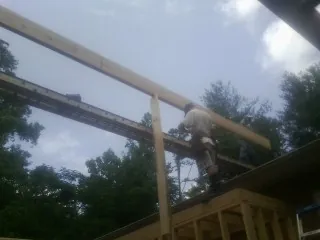 Carpenter setting a ridge beam over a new addition frame — Ice Dam Removal by Roofing Brothers in Houlton