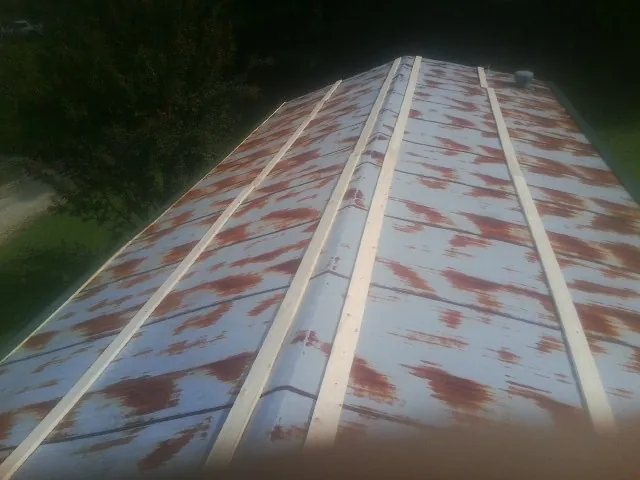 Rusted metal roof panels with new wood purlins before replacement — Storm Damage Roof Repair in Houlton by Roofing Brothers